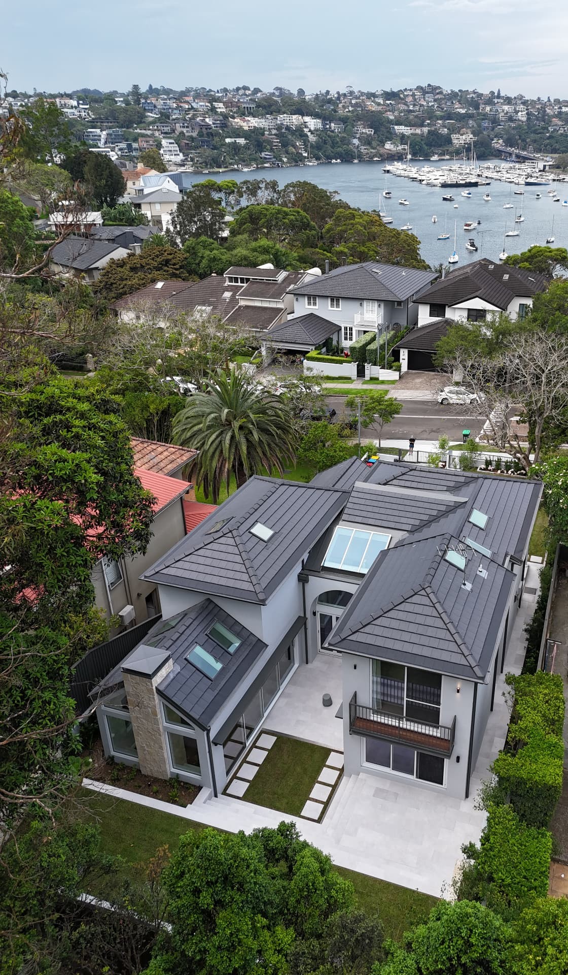 Aerial view of a modern Sydney home with a charcoal tile roof completed by Marvel Roofing Projects